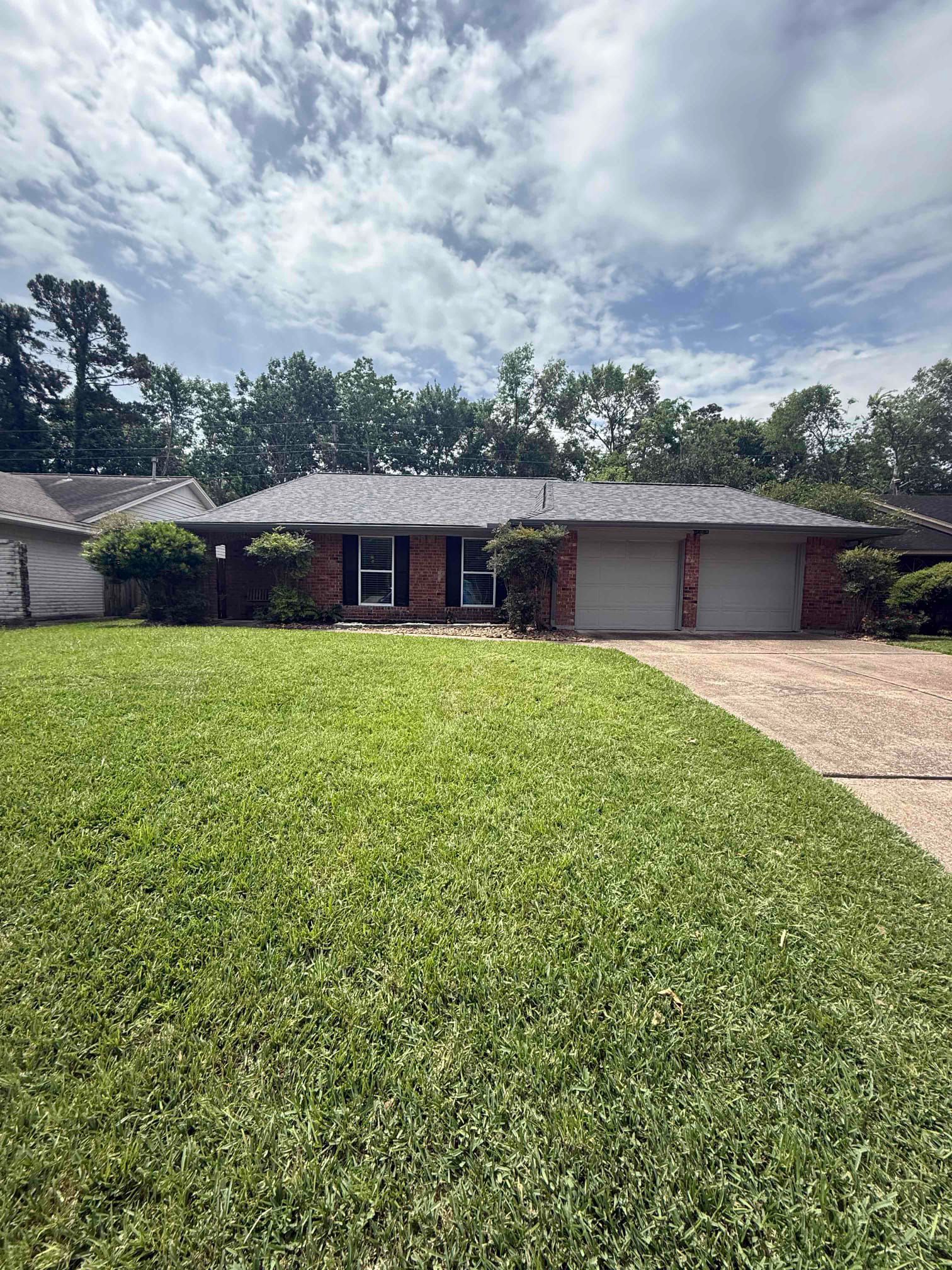 Completed architectural shingle roof installation on a brick residential home in Humble TX