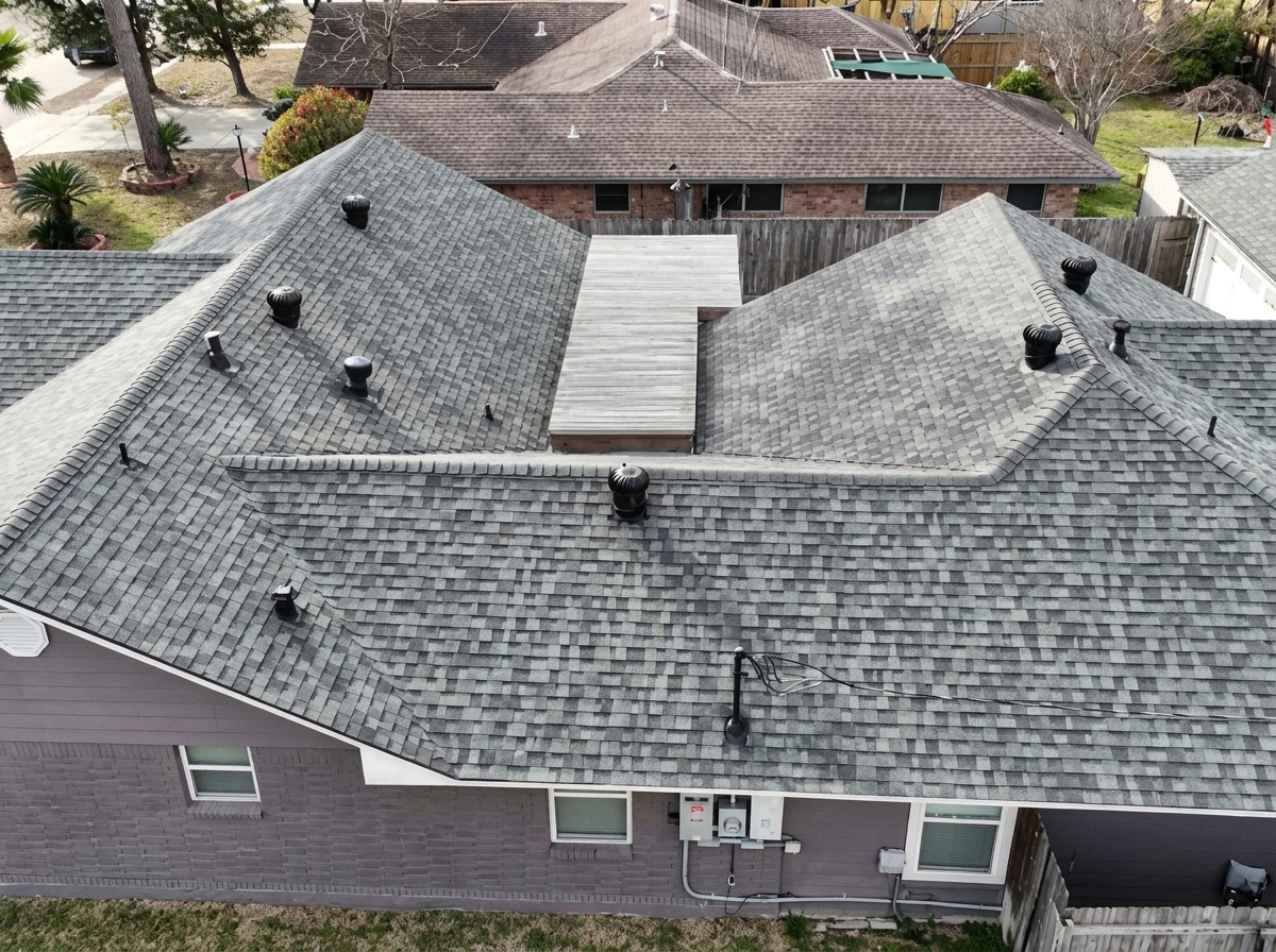 Aerial view of a freshly installed grey shingle roof in Conroe TX featuring multiple peaks, valleys, and built in ventilation caps