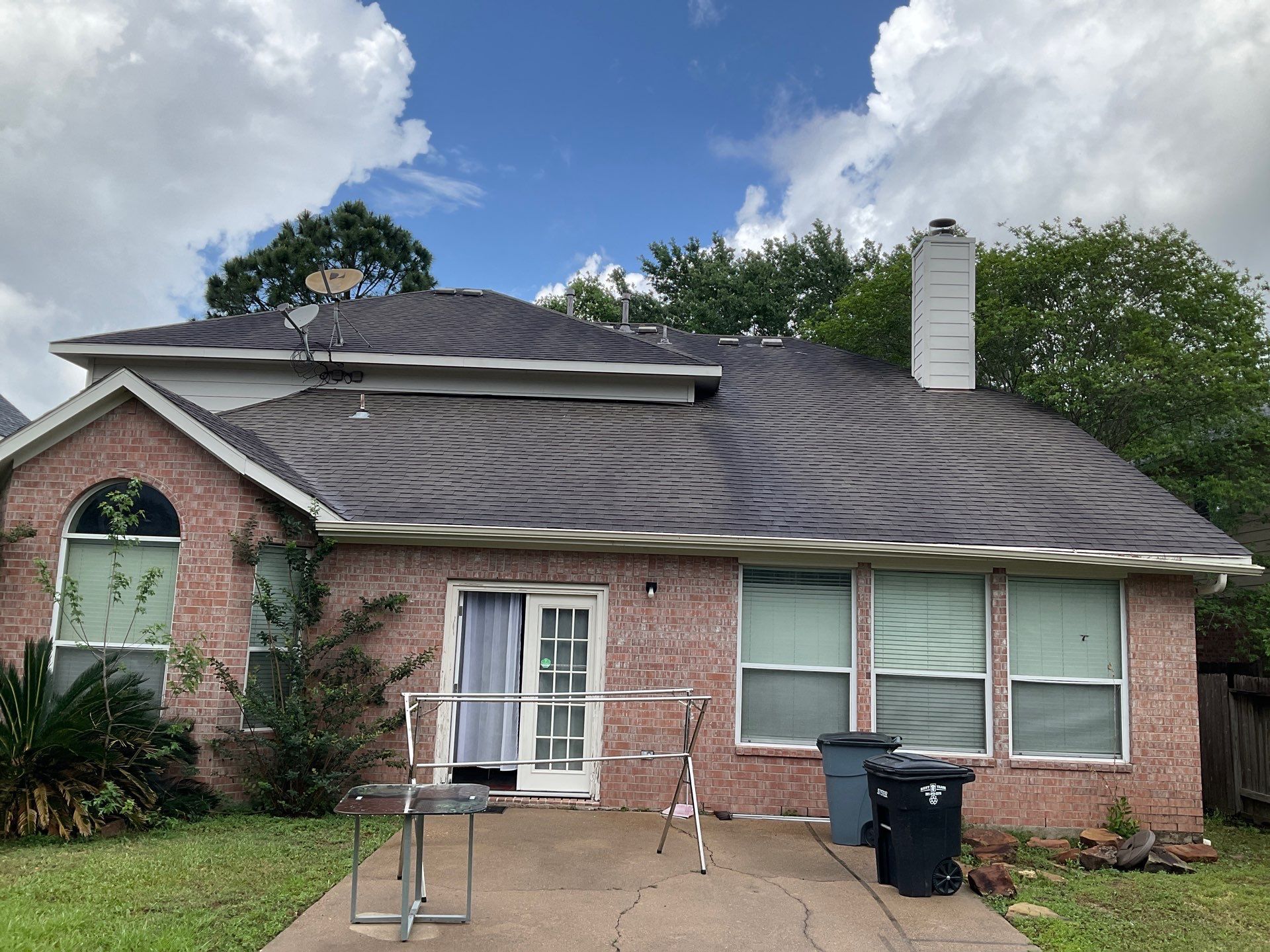 Old weathered roof on a brick home before a roof replacement in Tomball TX