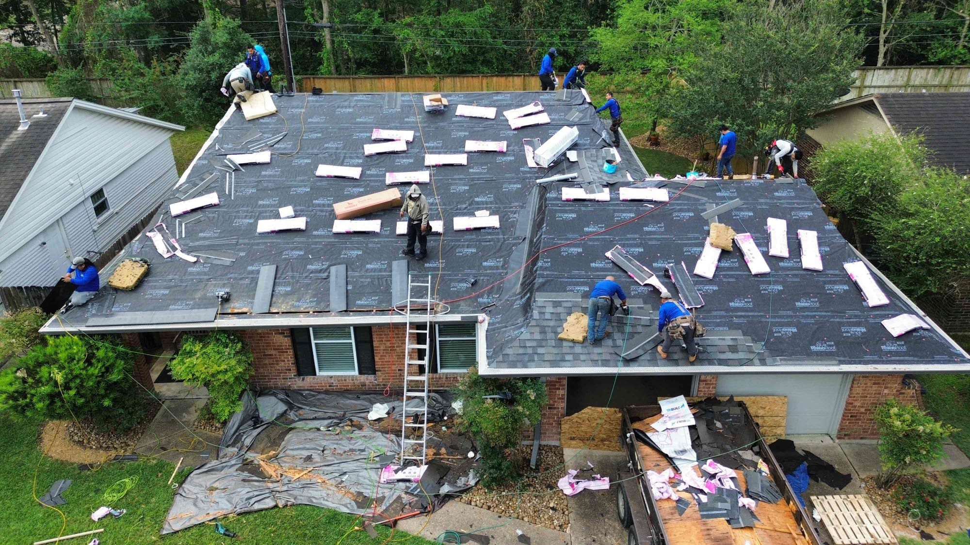 Roofing crew installing new underlayment and shingles during a roof replacement in Humble TX