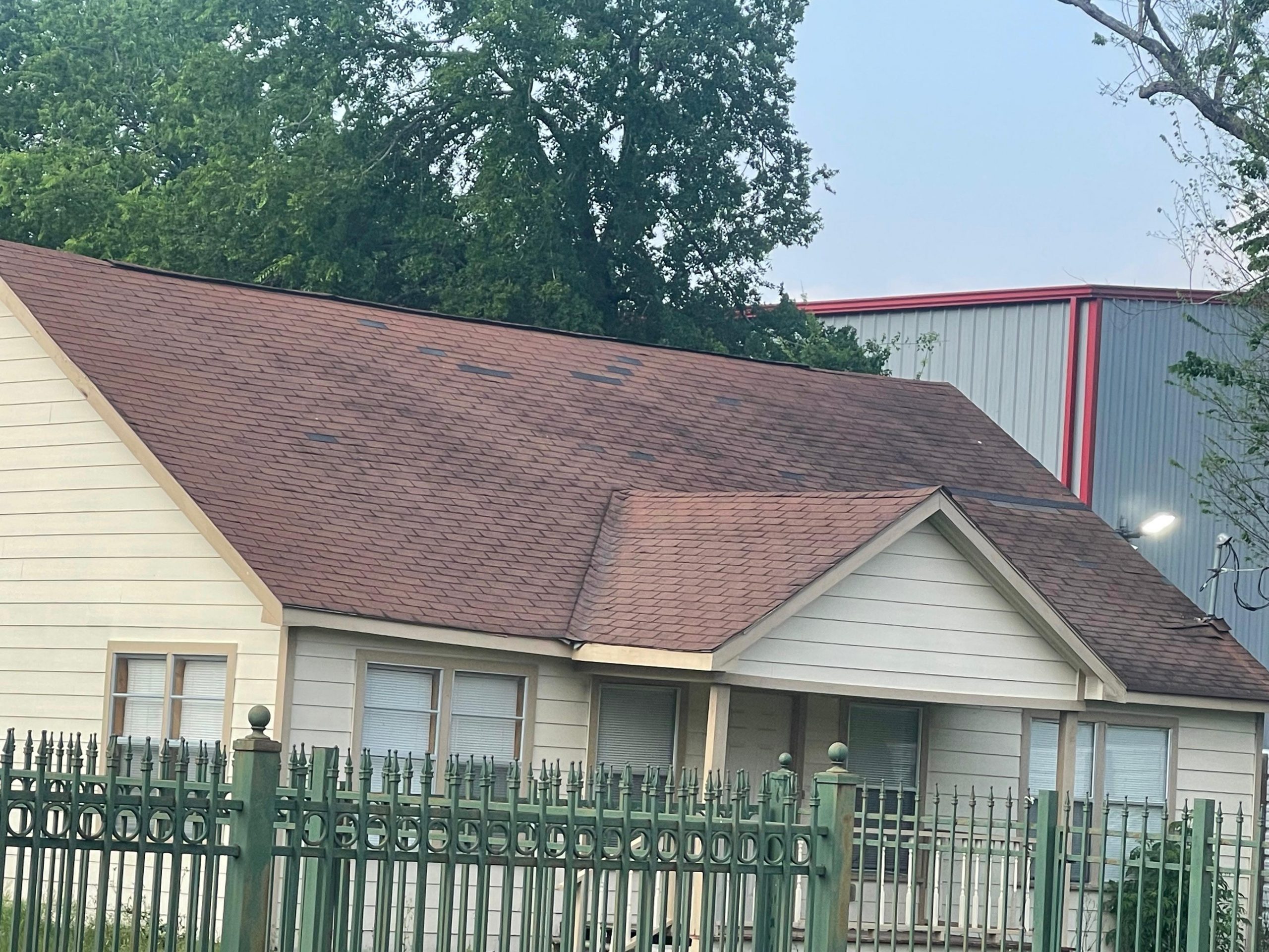 Weathered shingle roof on a residential home showing the effects of poor attic ventilation